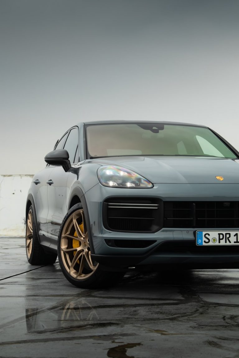 a grey porsche cayen is parked in a parking lot